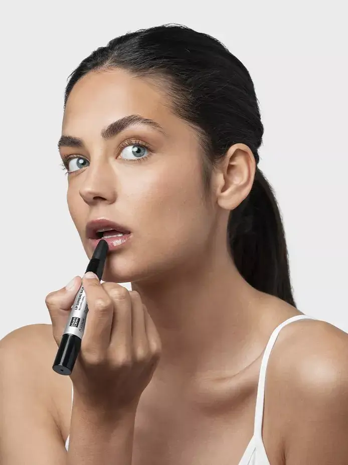 Modelo aplicándose Lip Supreme Balm